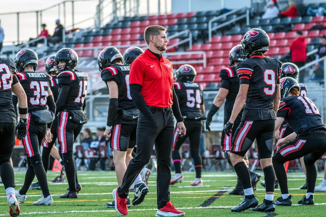 A coach watching athletes on the sideline during practice